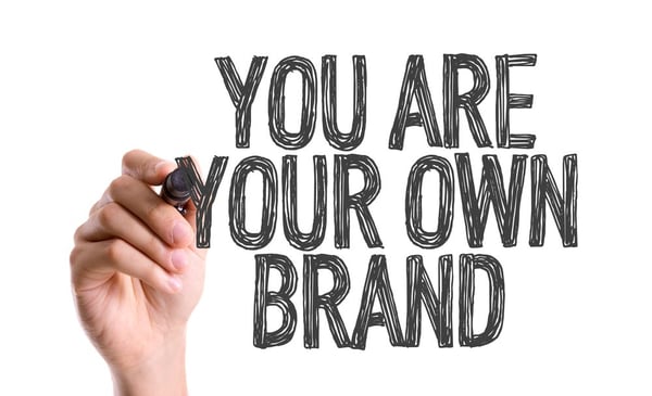 Hand with marker writing You Are Your Own Brand-1